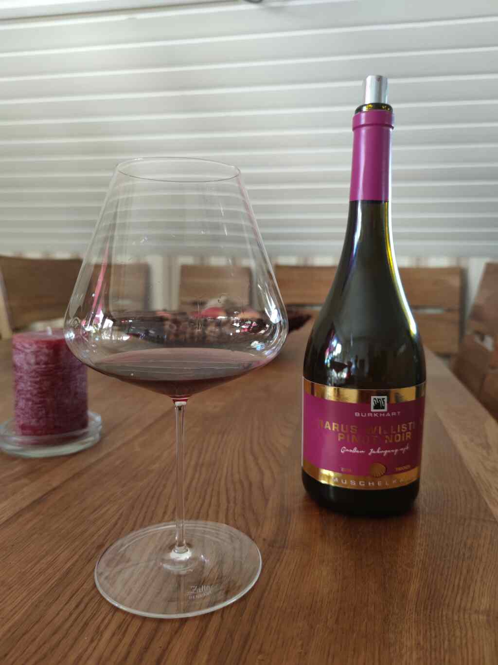 Eine Weinflasche und ein Weinglas in dem ein Pinot Noir von 2018 ist