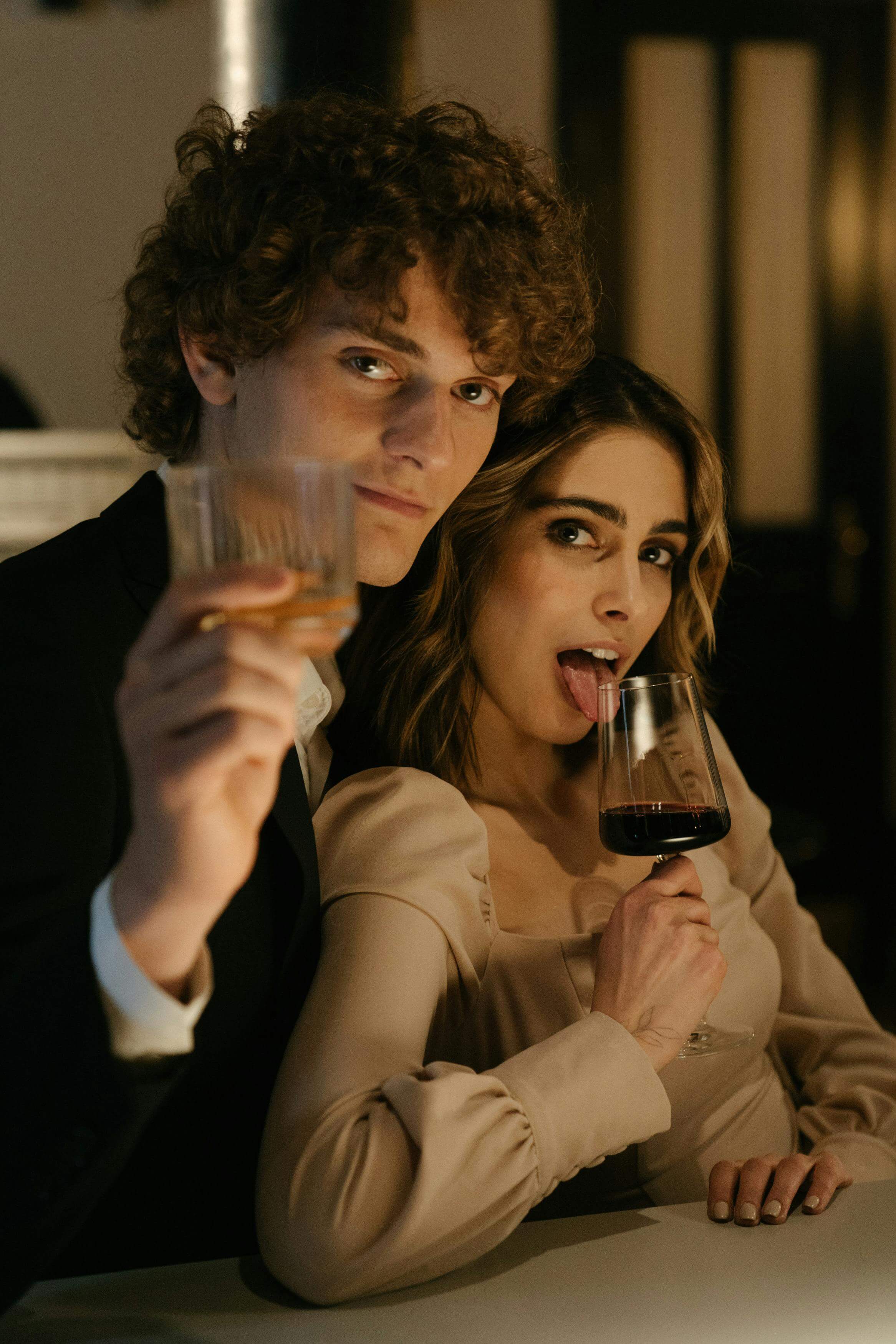 Junges Paar mit Wein und Whisky Glas